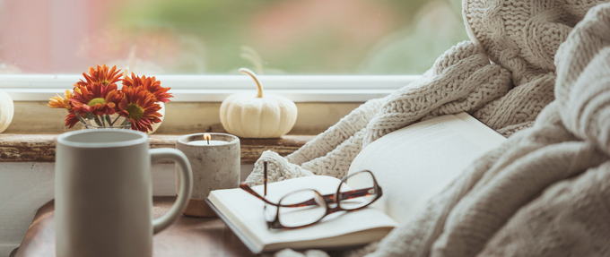 cozy photo of reading by a windowsill with fall vibes